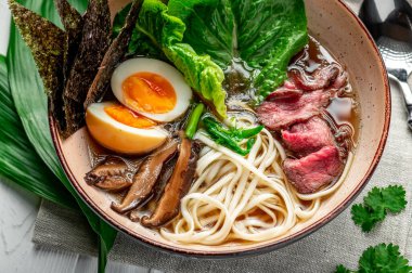 Pirinç erişteli Asya ramen çorbası, mantar ve siyah kasede domuz eti. Asya mutfağı. Lezzetli ve sağlıklı yiyecekler. Menü için fotoğraf.