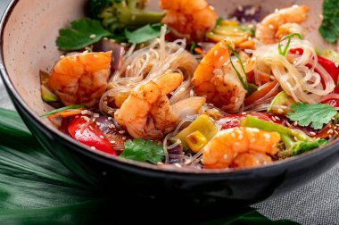 Rice noodles with shrimp and vegetables. Asian cuisine. Delicious and healthy food. Photo for the menu.