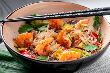 Rice noodles with shrimp and vegetables. Asian cuisine. Delicious and healthy food. Photo for the menu.