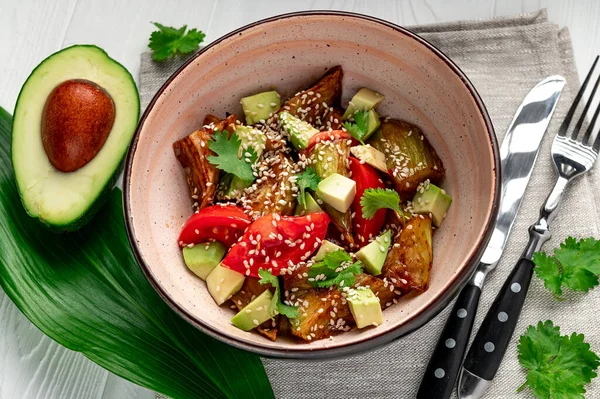 Fried eggplant with avocado, tomatoes and sesame seeds. Asian cuisine. Delicious and healthy food. Photo for the menu.