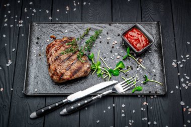 Siyah taş masanın üstünde biftek var. Menü için fotoğraf