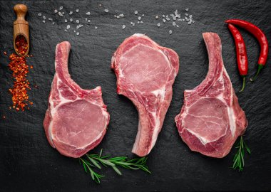 Fresh, raw pork steak with spices on a dark background. fresh meat