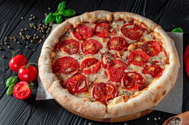 Siyah arka planda pizza margherita, üst manzara. Domates, fesleğen ve Mozzarella peynirli pizza..