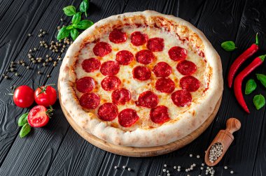 Lezzetli pepperonili pizza ve yemek malzemeleri domates fesleğenli sıcak biberli pizza manzaralı..