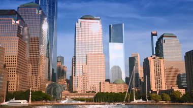 New York, ABD, 4 Temmuz 2025: Parlak güneş, yüksek binaların cephelerini kamaştırıyor. Nehirden New York 'un ufuk çizgisine alçak açı.