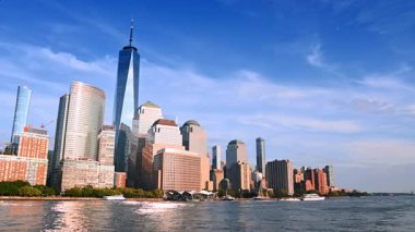 Güneş modern New York, ABD 'nin ufuk çizgisini aydınlatıyor. Nehirden binaların alçak açılı görüntüsü.