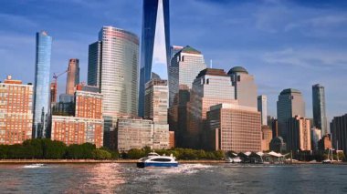 Tekne sersemletici ufuk çizgisi boyunca su manzarası boyunca hareket ediyor. Nehirden New York 'un mimarisine bak.