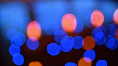Karanlık arka planda parlayan ışıkların bulanık görüntüsü. Kapatın. Çelenkler bulanıklaşıyor.