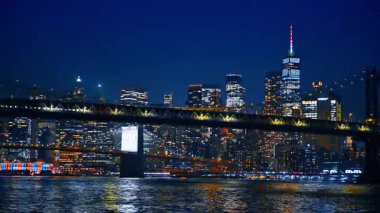 Modern metropolün canlı gece hayatı. Manhattan Köprüsü 'nün alçak açılı görüntüsü ve Doğu Nehri' nden New York silüeti..