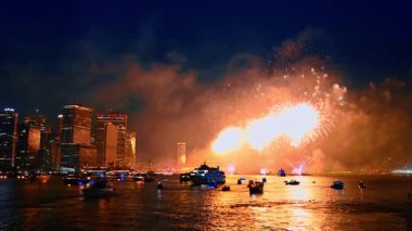 Gece gökyüzünde nehir manzarasında parlayan havai fişeklerin göz alıcı görüntüsü. New York, ABD 'de şenlik kutlaması.