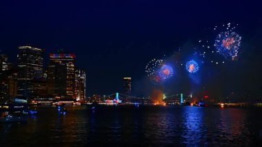 Su manzarası ve köprüler üzerinde nefes kesici havai fişek manzarası. New York, ABD 'nin Doğu Nehri' nden gece görüş açısı düşük.