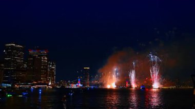 Geceleri nehir manzarası üzerinde muhteşem havai fişekler çakıyor. New York bayramı kutluyor. Su manzarasının perspektifi.