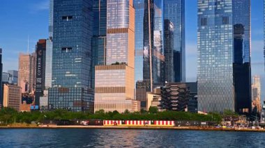 New York, ABD, 8 Temmuz 2025: Modern gökdelenlerle çevrili nehrin yeşil rıhtımına bakın. New York, ABD 'den tekne turu.