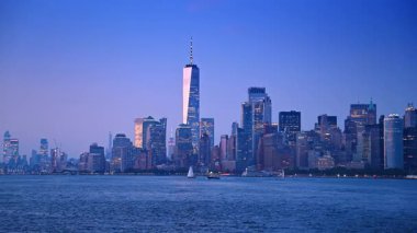 Günbatımında New York 'un güzel, modern silueti. Nehirden çarpıcı binaların alçak açılı görüntüsü.