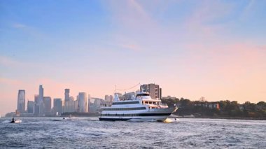 New York, ABD, 8 Temmuz 2025: Beyaz motorlu araç Hudson Nehri 'nden geçiyor. Günbatımında New York, ABD 'den tekne turu.