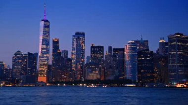 New York, ABD 'nin göz kamaştırıcı gece silueti. Nehir tekneleri nehir kıyısında gezer. Güzel şehrin tadını çıkarırlar..
