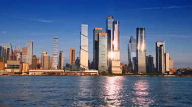New York, ABD, 8 Temmuz 2025, gün batımında New York 'un canlı bir silueti. New York 'un parlayan gökdelenleri güzel bir günbatımında suyu yansıtıyor, şehrin canlı mimarisini gözler önüne seriyor..