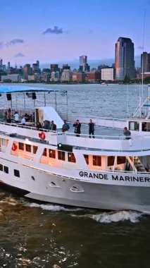 New York, ABD, 8 Temmuz 2025: NYC gece gezisi. Güneşin arka planda batmasıyla New York şehrinin ufuk çizgisi manzaralı denizde manzaralı bir tekne yolculuğunun tadını çıkarın..