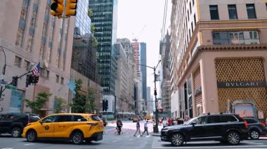 New York, ABD, 8 Temmuz 2025: New York sokaklarını keşfetmek. Kalabalık hareketli bir New York caddesinde toplanırken, sembolik binaların ve alışveriş alanlarının ortasından bir otobüs geçiyor..