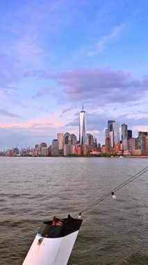 Büyük nehir teknesinde bir nehir gezisi. New York 'un silueti, arka planda güneşin batışı ışığında. Dikey video.