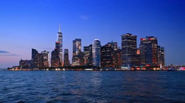 Gece Manhattan 'ın güzel aydınlanması. Koyu mavi deniz manzaralı New York siluetine yaklaşıyoruz..