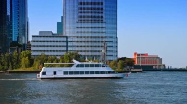 Jersey, ABD, 1 Temmuz 2025: Modern çift güverteli tekne nehir manzarası boyunca ilerliyor. Arkaplanda Manhattan 'ın silüeti.