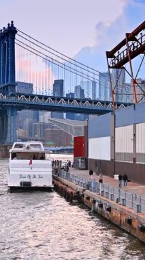 New York, ABD, 8 Temmuz 2025: Tekne ABD 'nin New York rıhtımında duruyor. Su manzarasından Manhattan Köprüsü 'nün manzarası. Dikey video.