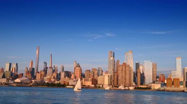 New York, ABD, 8 Temmuz 2025: Güneşli bir günde New York 'un ufuk çizgisi. Şehir manzarası, deniz manzarası, yelkenliler..