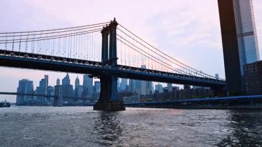 Doğu Nehri 'nin engebeli suları kıyıya yakın. Manhattan Köprüsü ve New York ufuk çizgisinin alçak açılı görüntüsü.