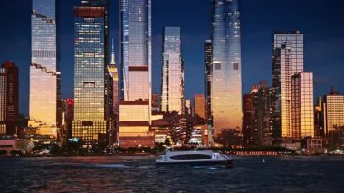 New York gökdelenlerinin cam cephelerine yansıyan parlak, yumuşak bir ışık. Modern bir tekne, bir gemi yapısı ile rıhtım boyunca hareket eder..