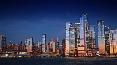 New York 'un finans merkezi nehrin su manzarası. Güneşin batışını yansıtan güzel gökdelenler.