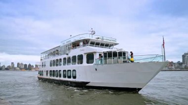 Modern çoklu güverte seyahat teknesi New York, ABD körfezinde duruyor. Aracın önünde Amerikan bayrağı var..