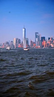 Hudson Nehri 'nde Manhattan silueti olan bir yelkenli. Hudson Nehri 'nde yelken açan yelkenli Manhattan silueti ve arka planda One World Trade Center.