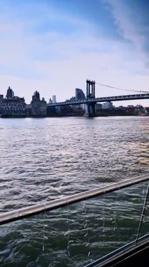 Manhattan Köprüsü 'nün doğu nehri üzerindeki manzarası. Manhattan Köprüsü doğu nehri boyunca uzanır. Arkasında binalar ve şehir silüeti vardır..