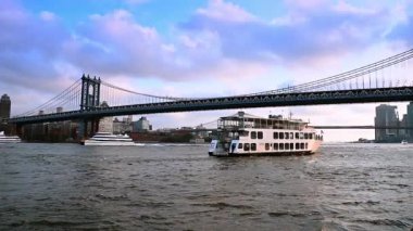 New York 'ta Manhattan Köprüsü' nün altından geçen yolcu feribotu. Beyaz bir yolcu feribotu Manhattan Köprüsü 'nün altından geçiyor..