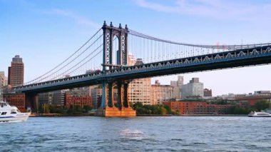 New York 'ta East River' da tekneleri olan Manhattan Köprüsü. Manhattan Köprüsü manzaralı. Arka planda tekneler ve şehir binaları var..