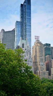 New York, ABD, 1 Ağustos 2025: Essex Evi ve New York şehrinin gökdelenleri. New York City gökdeleninde Essex Evi tabelası ve Central Park üzerinde modern cam kuleler var..
