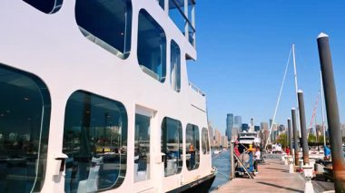 Jersey City, ABD, 11 Temmuz 2025, Jersey City ufuk çizgisi manzaralı tekne limana yanaştı. Arka planda Jersey City silueti olan modern bir yat marinada demirlemiş..