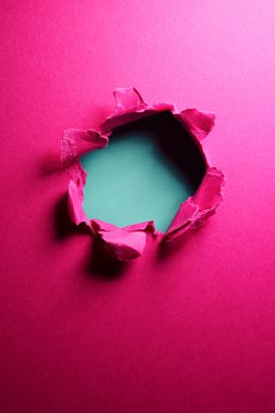 Ortasında delik olan pembe kağıt arkaplan