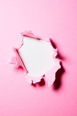 Ortasında delik olan pembe kağıt arkaplan