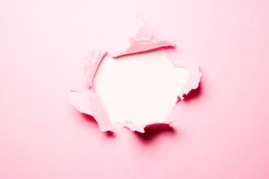Ortasında delik olan pembe yırtık kağıt arkaplan