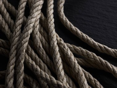 Eskimiş sert kenevir halatı siyah taş üzerinde siyah shibari arka planında