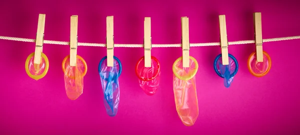Condoms Hanging Rope Pink Background — Stock Photo, Image