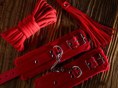 BDSM seks oyuncakları kırmızı renge bürünmüş eski ahşap zemin üzerine kurulmuş
