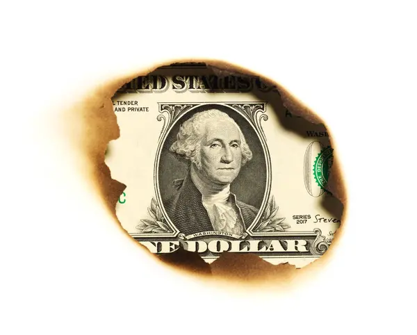 燃烧的储蓄概念背景 一块钱纸在洞里 免版税图库图片