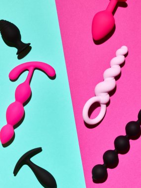 Sex toys background. Anal plugs and dildo over blue and pink backdrop