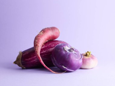 Mor arka planda çiftlik organik sebzeleri. Kohlrabi, patlıcan ve turp.