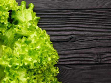 Siyah ahşap arka planda yeşil salata yaprakları