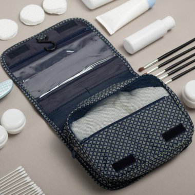 Seyahat kozmetik seti gri arka planda. Tuvalet eşyası çantası. Gri renkli beyaz kadın kozmetik şişeleri. Bir grup plastik koruma şişesi. Tasarım için boş alan. Beyaz Kozmetik kapları kümesi, kopya alanı ile üst görünüm.