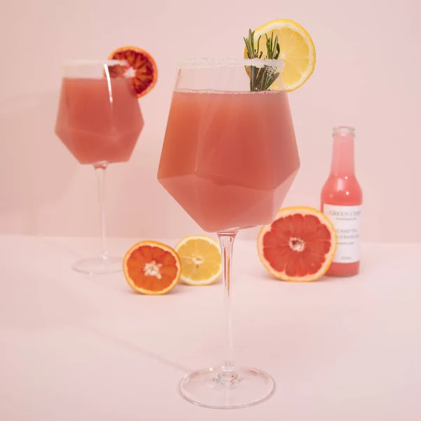 优雅的时髦 时尚的鸡尾酒 带有柑橘类水果和迷迭香粉红背景的干酒杯 夏季艺术饮料的概念 模拟模版 — 图库照片